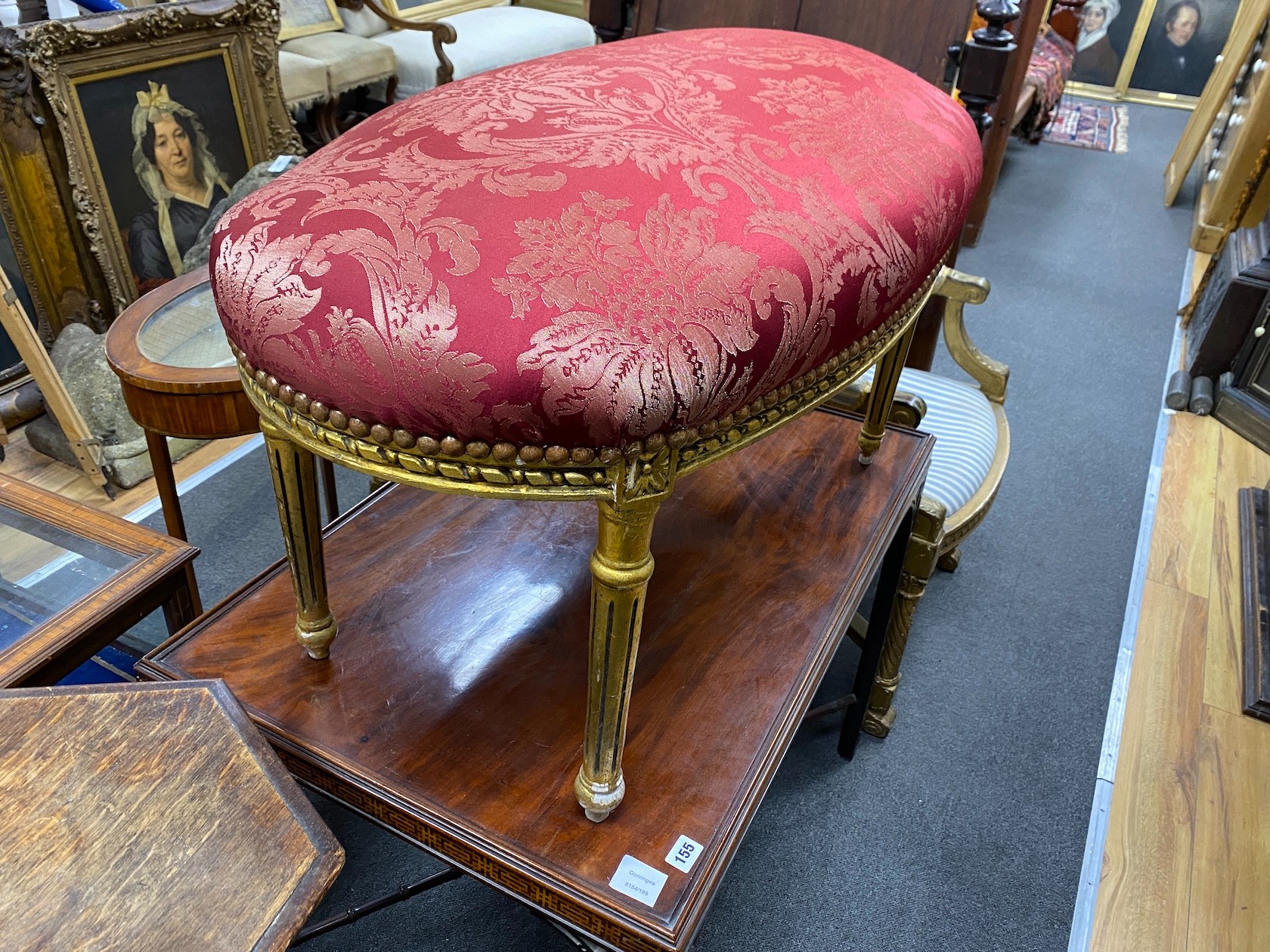 A Louis XVI style oval giltwood upholstered dressing stool, length 90cm, depth 50cm, height 50cm